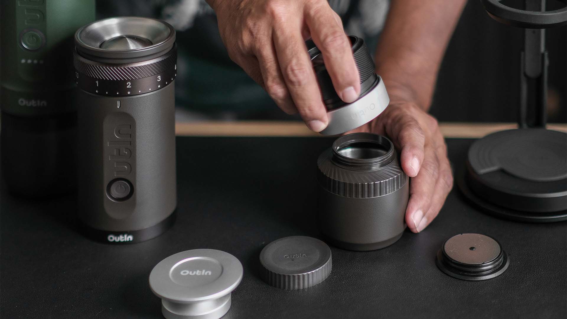 Hands assembling the Outin portable electric grinder to prepare fresh grounds for a perfect espresso shot
