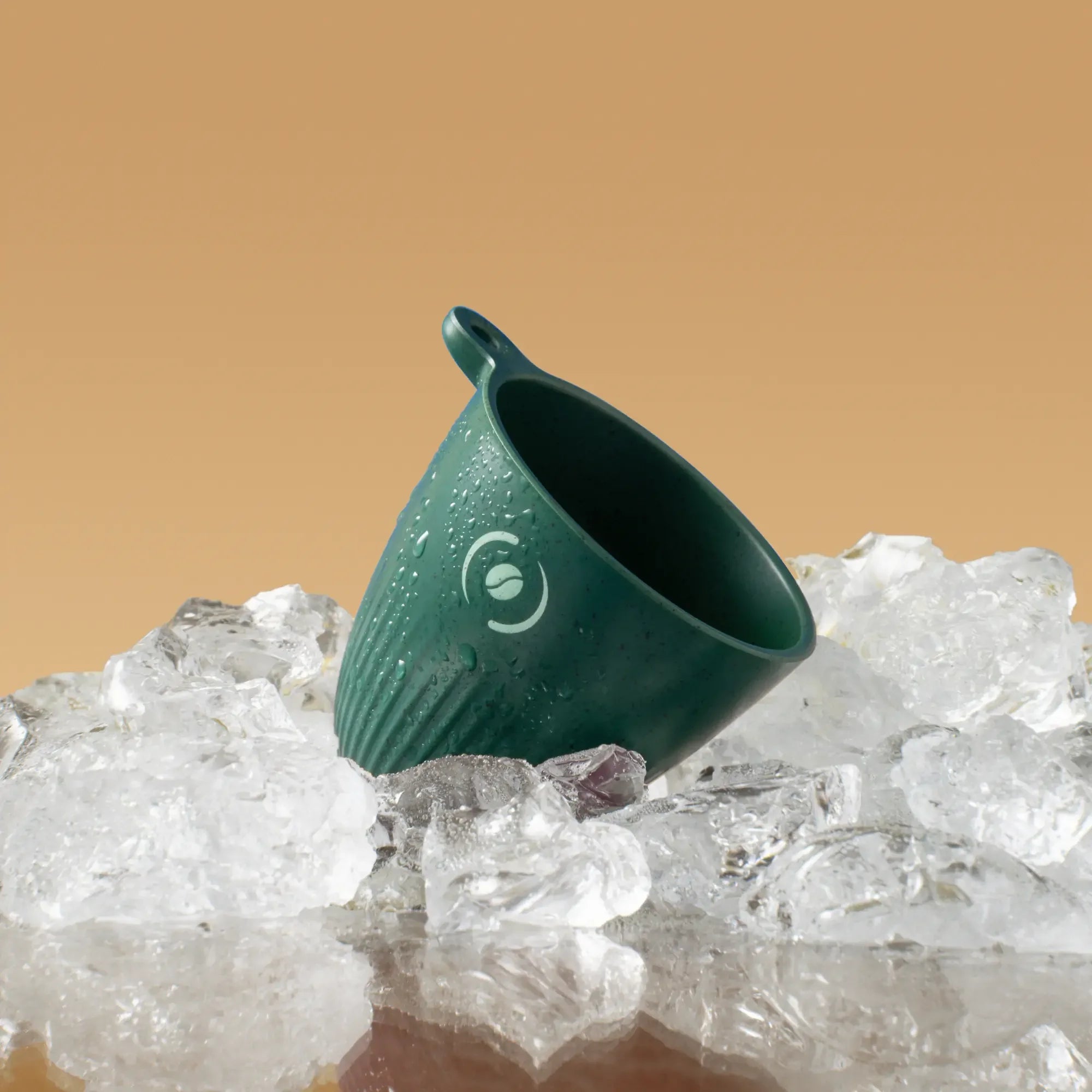 OutIn Rebrew dark green espresso cup on ice, showcasing cold beverage temperature resistance.