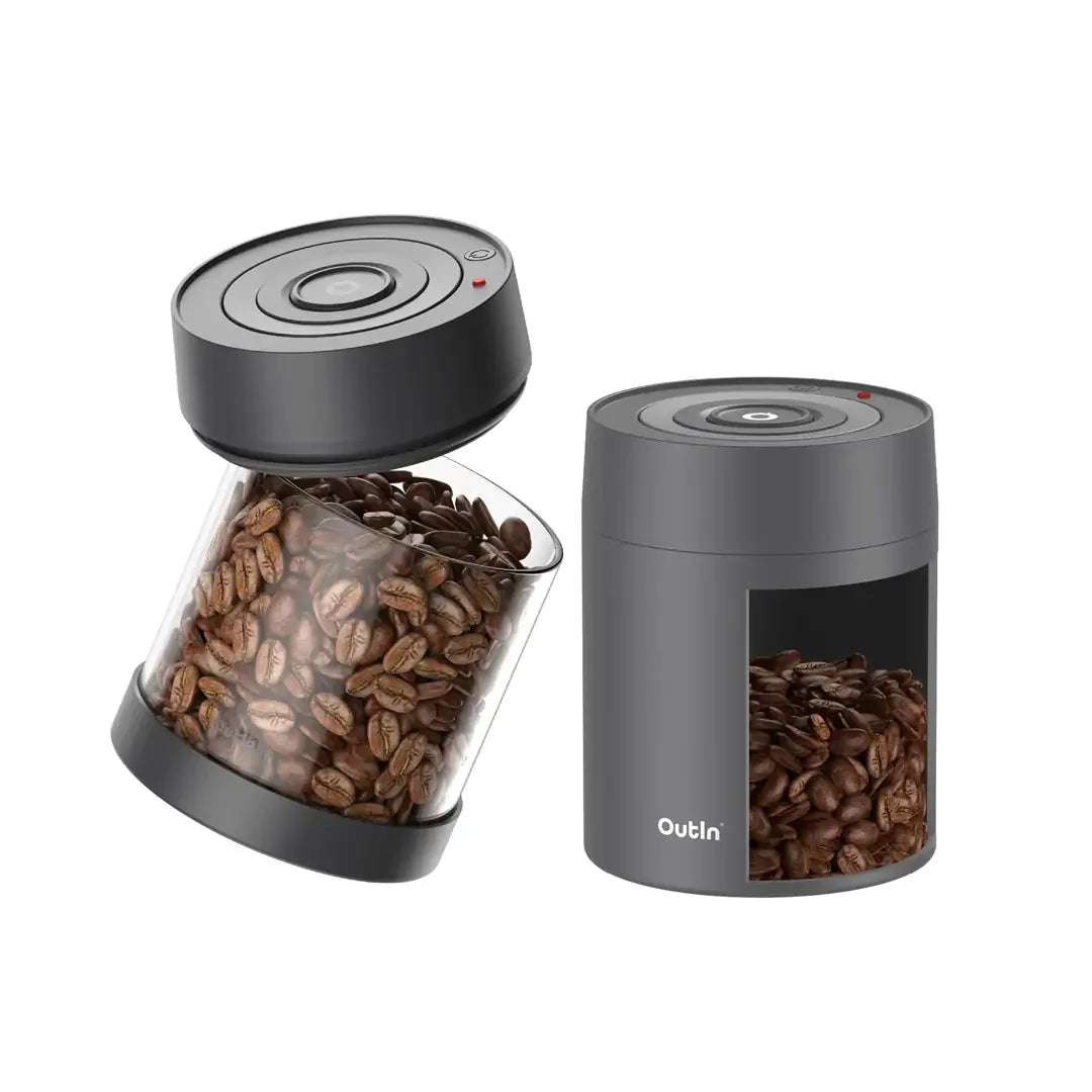 Two portable electric vacuum coffee canisters, one glass with coffee beans, the other sealed gray with coffee beans visible.