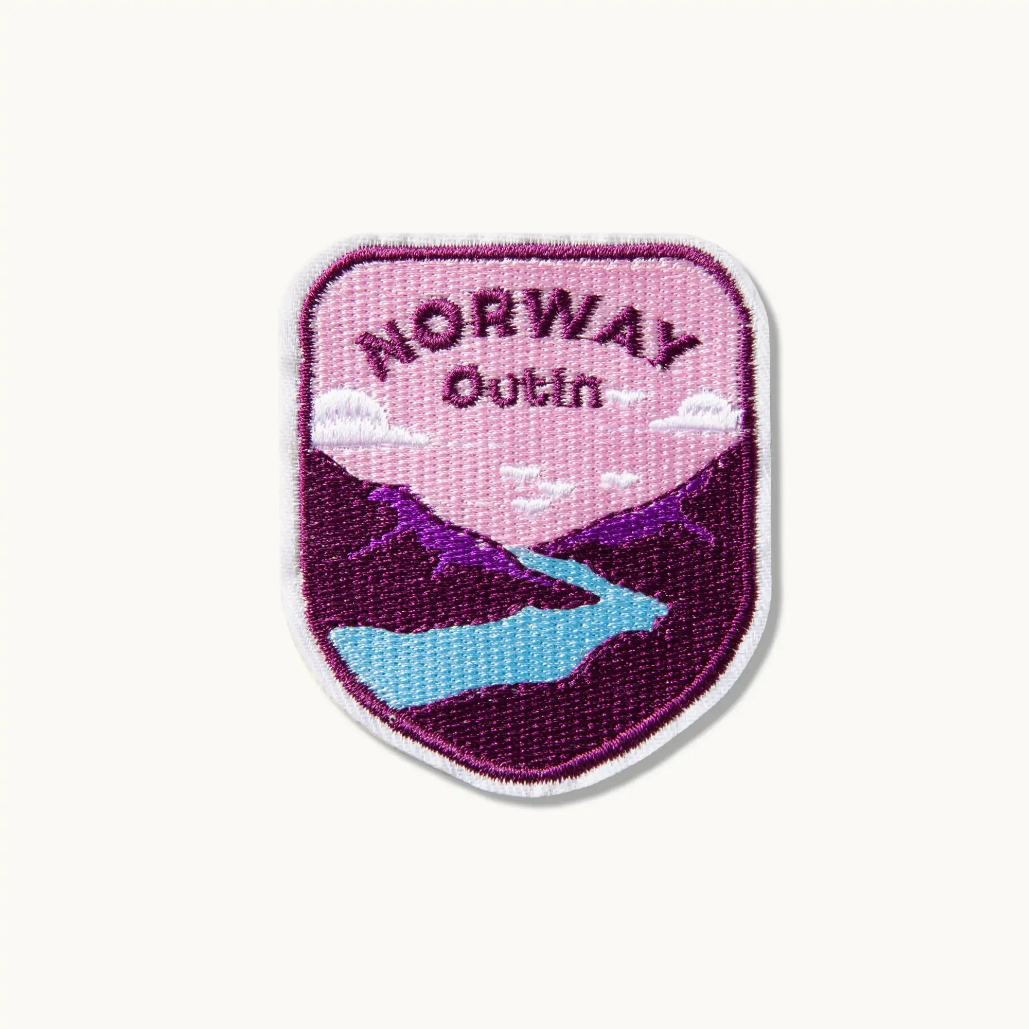 OutIn Norway embroidered patch with purple mountains, blue river, and pink sky. Features 'NORWAY' and 'OutIn' text.
