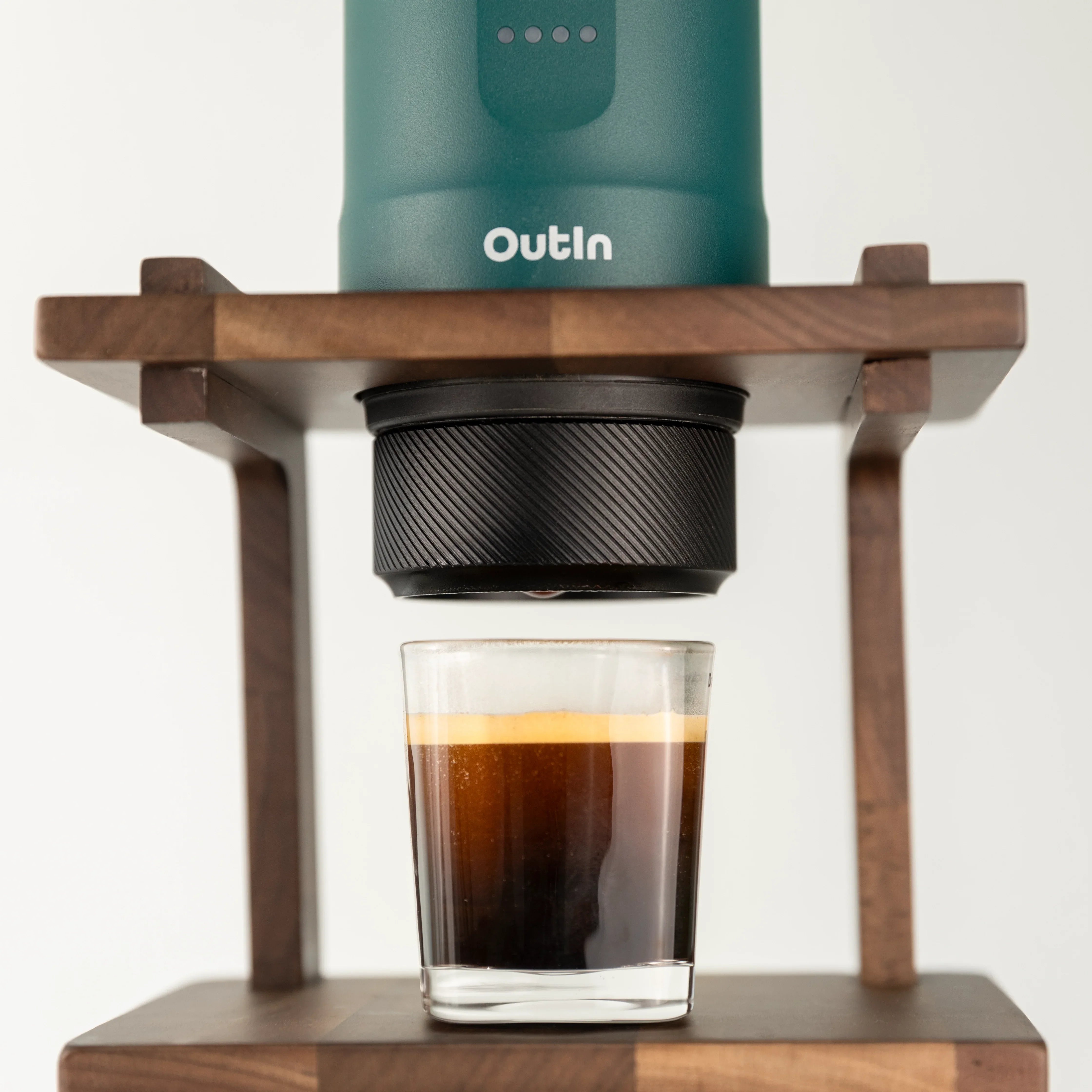 Teal OutIn Nano portable espresso machine brewing double espresso into glass with 16-18g basket.