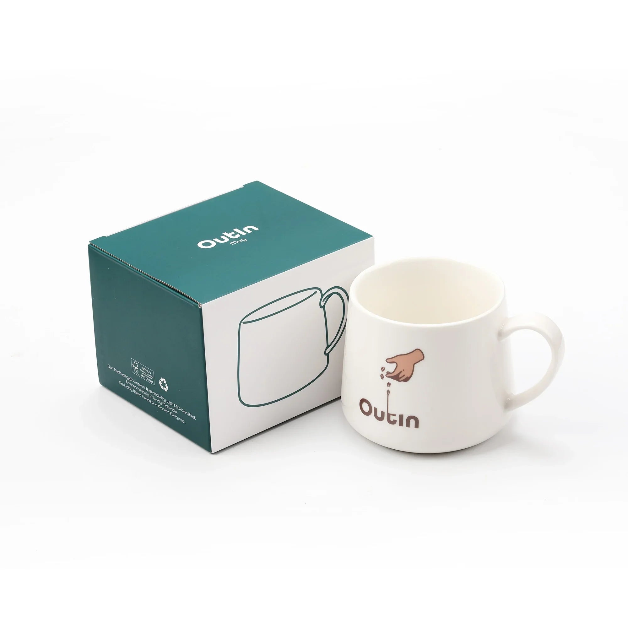 OutIn portable espresso machine mug, white ceramic with graphic, next to teal retail box.