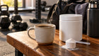 Cup of coffee and creatine powder on a gym table