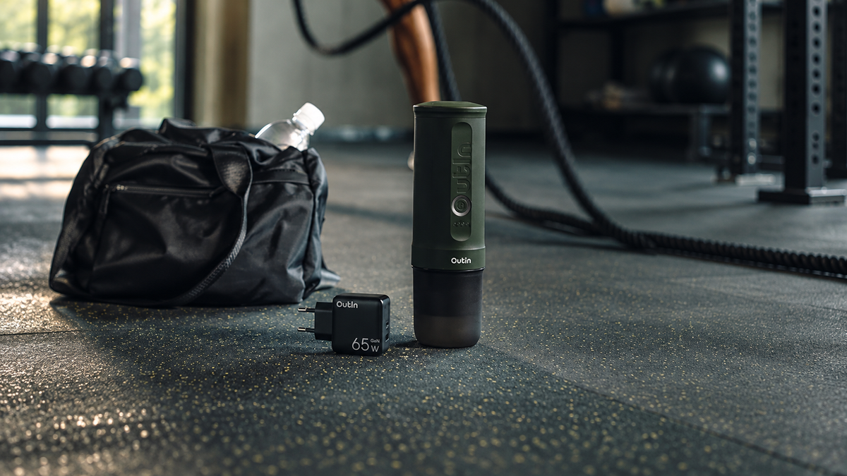 OutIn Nano 2 Portable Espresso Machine beside a gym bag before a workout