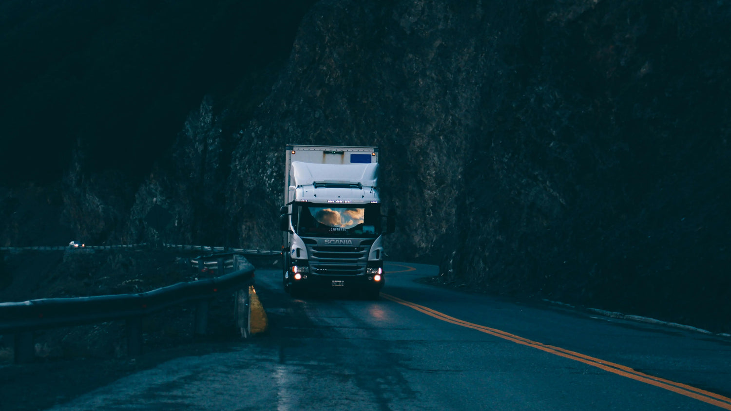 Scania truck driving through mountain tunnel at night