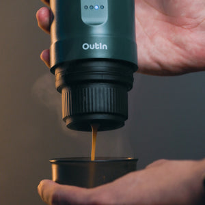 Portable Outin Nano Espresso Machine brewing coffee directly into a cup.