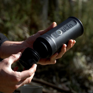 User demonstrating the detachable part of the Nano Portable Espresso Machine