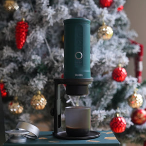 Outin Nano portable coffee machine in Outin Teal, on an adjustable coffee stand