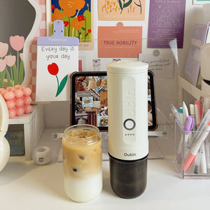 Nano Portable Espresso Machine in pearl white on a desk.