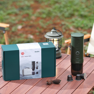 Outin Traveler Espresso Gift Set in Forest Green with box and espresso machine outdoors.