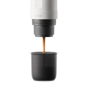 Espresso pouring from Nano Portable Espresso Machine into a black cup.